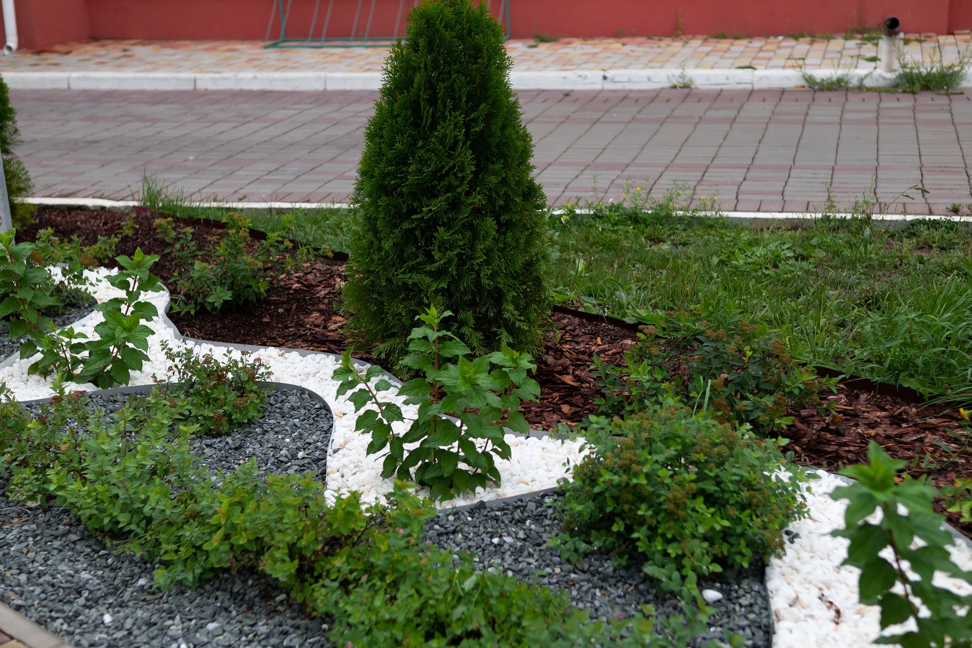 Landscape design in green garden, panoramic view of nice landscaped yard of residential house. Paving path, plants and vintage lantern in home backyard, beautiful landscaping in summer.